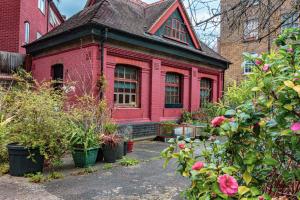 a red house with plants in front of it at Unique Detached House wPrivate Courtyard, London in London