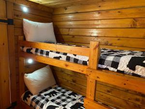 a bedroom with two bunk beds in a log cabin at Homely Poolside Cabin in Salisbury