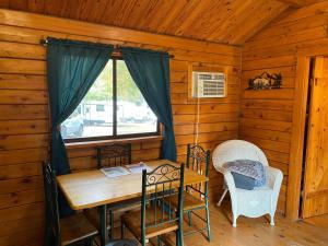 a dining room with a table and chairs in a cabin at Homely Poolside Cabin in Salisbury