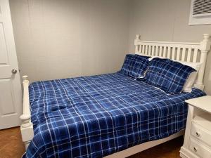 1 cama con manta azul a cuadros y 2 almohadas en Modern Woodland Cabin With Pool View, en Salisbury