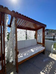 a wooden pergola with a bed on a balcony at Apart Riviera Tower Suites in Villa Carlos Paz