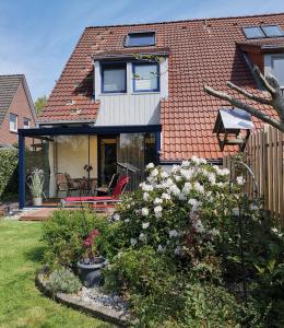 uma casa com um quintal com flores em Ferienhaus Medemsonne em Otterndorf