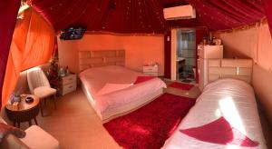 a bedroom with two beds and a red ceiling at Bubble castle house in Kerak