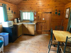 a kitchen in a log cabin with a table and a microwave at Poolside Rustic Cabin with Amazing Views in Salisbury +10 photos