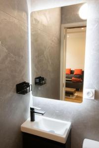 La salle de bains est pourvue d'un lavabo, d'un miroir et d'un canapé. dans l'établissement Cozy studio in Villefranche-sur-Mer, à Villefranche-sur-Mer