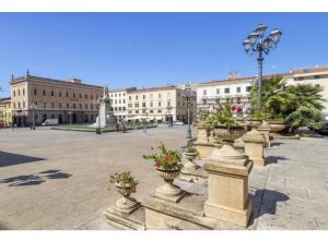 una plaza con macetas de flores en una ciudad con edificios en SestraHome Le 3 casette Free parking, en Sassari