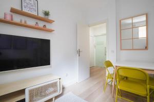 sala de estar con TV, mesa y sillas en Cozy apartment-2Bedrooms 1Bathroom-Atocha, en Madrid