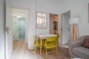 a living room with a table and yellow chairs at Cozy apartment-2Bedrooms 1Bathroom-Atocha in Madrid