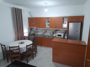a kitchen with a table and a kitchen with a microwave at Villa Besart in Berat