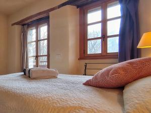 a bedroom with a large bed with two windows at Villa Rustica in Sorico
