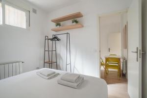 a white bedroom with a white bed and a yellow chair at Cozy apartment-2Bedrooms 1Bathroom-Atocha in Madrid
