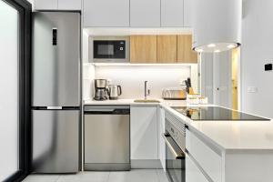 a white kitchen with a stainless steel refrigerator at Sunshine in Pilar de la Horadada