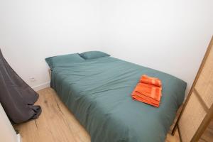 - une serviette orange assise au-dessus du lit dans l'établissement Cozy studio in Villefranche-sur-Mer, à Villefranche-sur-Mer