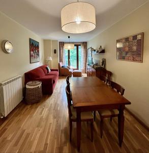 sala de estar con mesa y sofá rojo en Sallent de Gállego - Formigal - Pirineos Sur, en Sallent de Gállego
