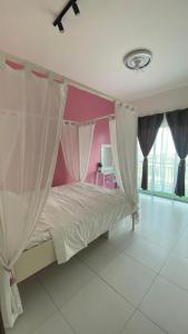 a bedroom with a bed with pink walls and curtains at R&R Manjung Guest House at Pangsapuri Samudera in Seri Manjung