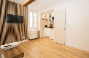 um quarto com uma cozinha e uma televisão na parede em Cozy studio in Villefranche-sur-Mer em Villefranche-sur-Mer