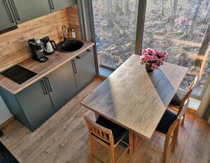 a kitchen with a table with a vase of flowers on it at Brīvdienu māja Empagi in Lādezers +13 photos