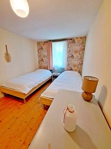 - une chambre avec deux lits et une table avec une lampe dans l'établissement Cottage l'Atelier, piscine, terrain de loisirs, à Marigny