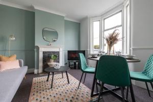 sala de estar con mesa y sillas verdes en Perry Place - Forest Hill- 3 bed house en Londres