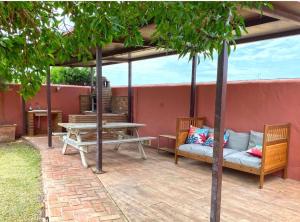 een patio met een tafel, een bank en een picknicktafel bij Casa Fatima in El Palmar
