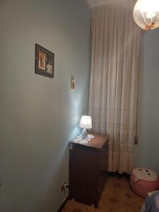 a lamp on a dresser in a room with a curtain at La casa di Lili in Lugnano in Teverina