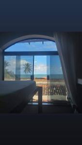 um quarto com vista para a praia e para o oceano em hostel quintal da sereia em Salvador
