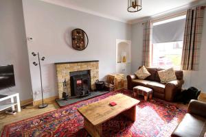 a living room with a couch and a fireplace at Crossing Cottage, Brora in Brora