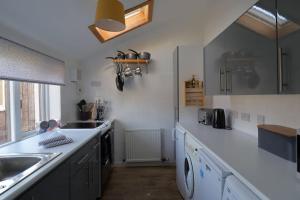 uma cozinha com um lavatório e uma bancada em Crossing Cottage, Brora em Brora