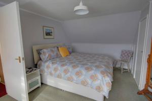 a bedroom with a bed with a blue comforter at Crossing Cottage, Brora in Brora