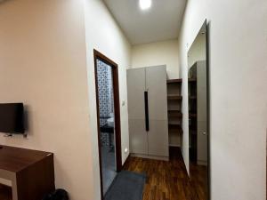 een lege kamer met een koelkast en een spiegel bij Sanjay Home Stay in Kodaikānāl