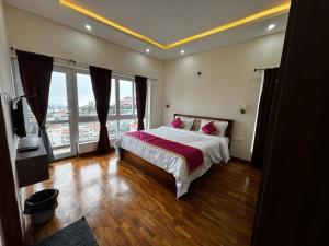 een slaapkamer met een groot bed en grote ramen bij Sanjay Home Stay in Kodaikānāl