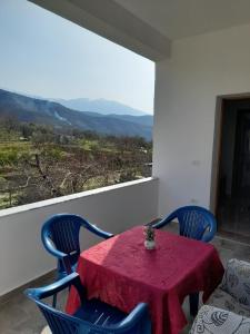una mesa con sillas azules y un mantel rojo en Villa Besart en Berat