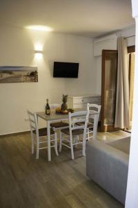 une salle à manger avec une table et des chaises blanches dans l'établissement Grazioso bilocale a Santa Teresa di Gallura, à Santa Teresa Gallura