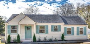 uma pequena casa branca com uma porta azul em Taylor Swift Eras Inspired Home-10 min to Broadway em Nashville