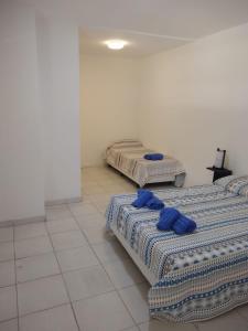 two beds in a room with blue towels on them at Casa Amplia 5 personas con Jardin y Parrilla in Tigre