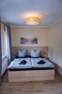 a bedroom with a bed with two pillows on it at Haus Strandglück - Urlaub mit Blick auf den Dümmer See in Lembruch