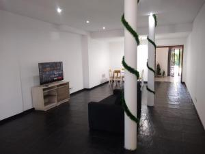 a living room with a tv and a couch and a table at Casa Amplia 5 personas Con Pileta, Amplio Jardin y Parrilla Zona Muy Tranquila en Tigre Centro in Tigre