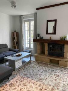 a living room with a couch and a fireplace at Maison chaleureuse en face de la forêt - proche INSEAD in Fontainebleau