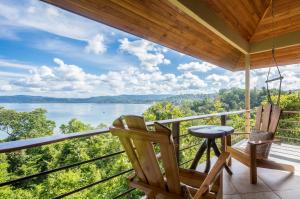 a balcony with two chairs and a view of a lake at Drake Bay Getaway Resort in Drake