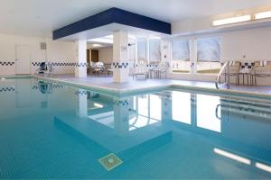 a large swimming pool with blue tiles in a building at Hampton Inn & Suites Fort Wayne-North in Fort Wayne