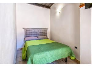 a bedroom with a bed with a green blanket on it at SestraHome in Sassari