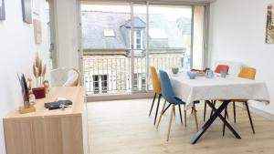 een tafel en stoelen in een kamer met een groot raam bij Ti An Alré, appartement 4 p en centre ville in Auray