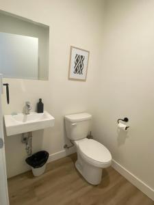 a bathroom with a white toilet and a sink at APPART-HOTEL L'UNI in Quebec City