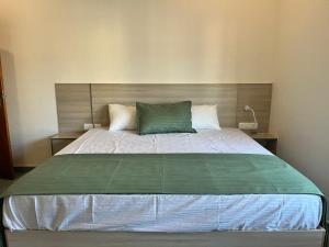 BAVA AC Rooms at Casa de Aadi في فاركَالا: غرفة نوم بسرير كبير ومخدة خضراء