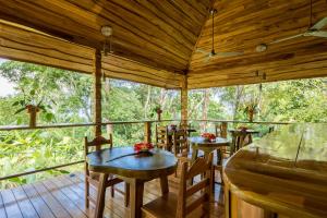 una habitación con mesas y sillas en una terraza en Drake Bay Getaway Resort by Sandglass, en Drake
