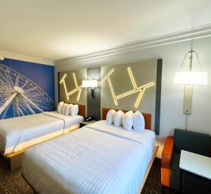 two beds in a hotel room with lights on the wall at The Walden, Trademark Collection By Wyndham in Pigeon Forge