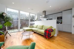 a living room with a couch and a table at GuestReady - Modern lodge with garden in London