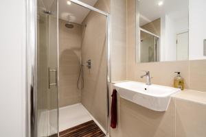 a bathroom with a sink and a shower at GuestReady - Modern lodge with garden in London