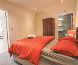 a bedroom with a large bed with red sheets at Cambridge Mews in Cleethorpes