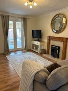 a living room with a fireplace and a tv at Stylish house centrally located in Bury Saint Edmunds